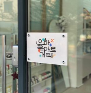 미미살롱 대구율하점 입구 유리창에 붙은 율하아트거리 사인보드